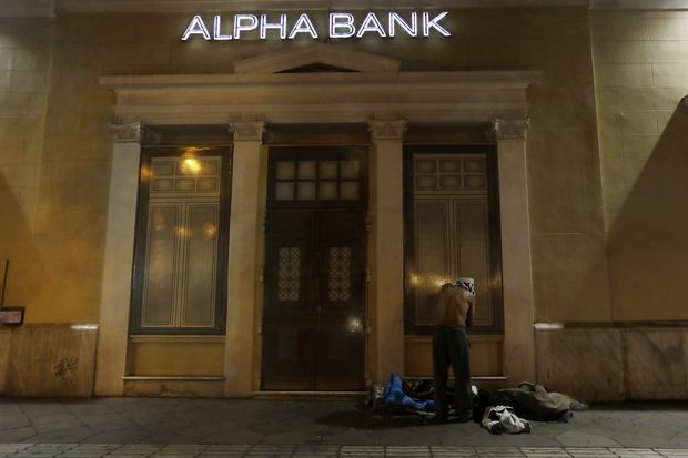 Sem-teto troca de roupa do lado de fora de banco em Atenas
