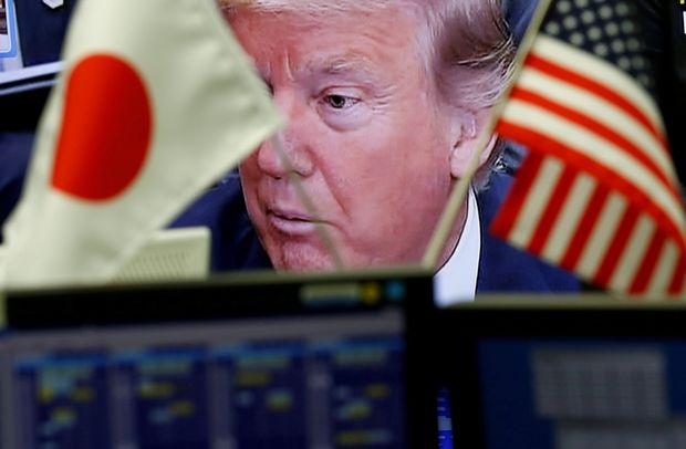 FILE PHOTO: A TV monitor showing U.S. President Donald Trump is seen through national flags of the U.S. and Japan at a foreign exchange trading company in Tokyo, Japan February 1, 2017. REUTERS/Kim Kyung-Hoon/File Photo ORG XMIT: ROP500