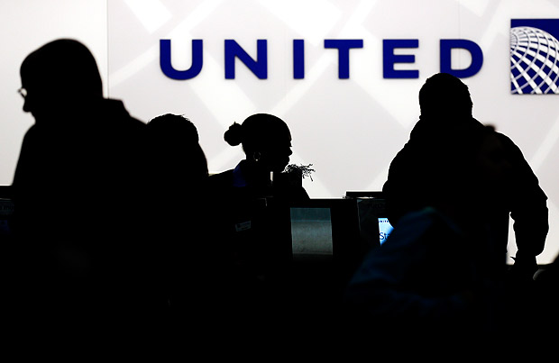 FILE - In this Saturday, Dec. 21, 2013, file photo, travelers check in at the United Airlines ticket counter at Terminal 1 in O'Hare International Airport in Chicago. After a man is dragged off a United Express flight on Sunday, April 9, 2017, United Airlines becomes the butt of jokes online and on late-night TV. Travel and public-relations experts say United has fumbled the situation from the start, but it's impossible to know if the damage is temporary or lasting. Air travelers are drawn to the cheapest price no matter the name on the plane. (AP Photo/Nam Y. Huh, File) ORG XMIT: NYBZ281