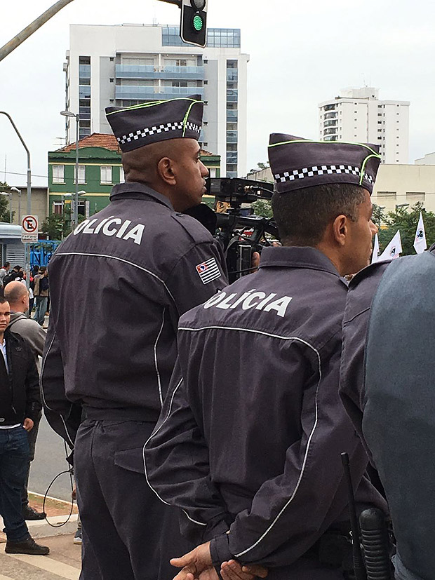 Um policial militar registra os manifestantes, que gritam "fora rede globo"