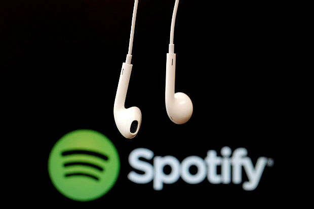 ILE PHOTO: Headphones are seen in front of a logo of online music streaming service Spotify, February 18, 2014 REUTERS/Christian Hartmann/File Photo ORG XMIT: SJF401