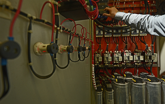 Funcionrio da empresa Vibrasil inspeciona equipamento conhecido como banco de capacitores