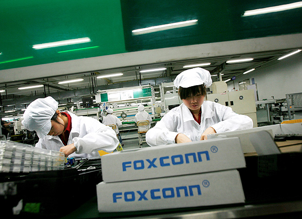 Trabalhadores em fábrica da Foxconn, empresa de origem taiwanesa que produz iPhones 