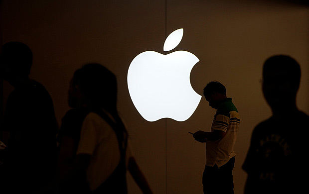 Homem olha tela do celular em frente a loja da Apple em Xangai, China: empresa exclui aplicativos