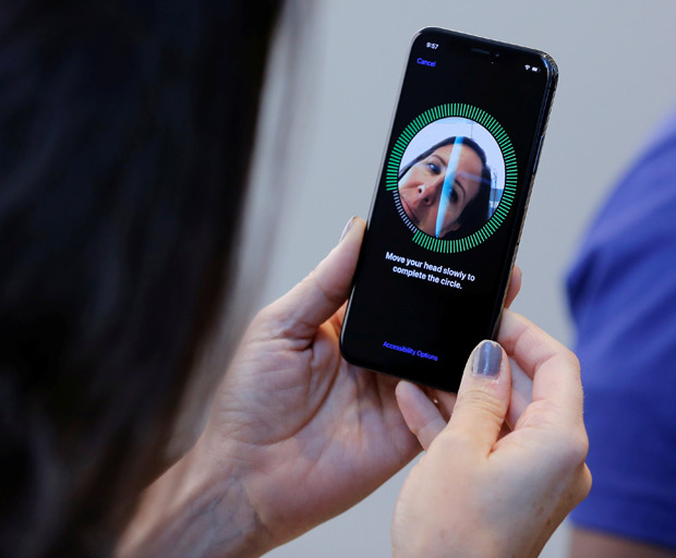 A woman sets up her facial recognition as she looks at her Apple iPhone X at an Apple store in New York, U.S., November 3, 2017. REUTERS/Lucas Jackson ORG XMIT: LJJ021