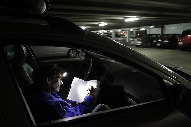 Professora Ellen Tara James-Penney corrige trabalhos dos alunos dentro do carro onde dorme 