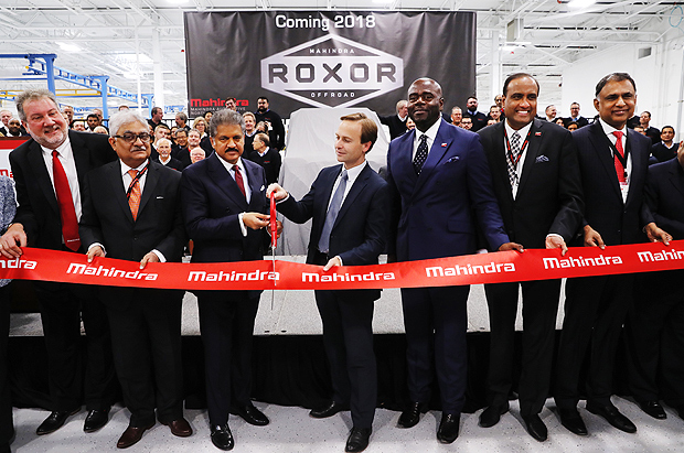 Mahindra Group Chairman Anand G. Mahindra, third from left, participates with Michigan Lt. Gov. Brian Calley, fourth from left, in a ceremonial ribbon butting in Auburn Hills, Mich., Monday, Nov. 20, 2017. Indian conglomerate Mahindra Group is opening an automotive manufacturing facility near Detroit. Mahindra says it will make an off-road vehicle at the 400,000-square-foot plant in Auburn Hills. (AP Photo/Paul Sancya) ORG XMIT: MIPS104