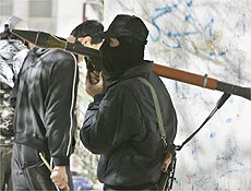Homem armado ligado ao Hamas carrega lanador de foguetes em rua de Gaza 
