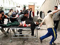 Iraquiano ferido em explosão é levado para hospital; 135 morrem em ataque suicida