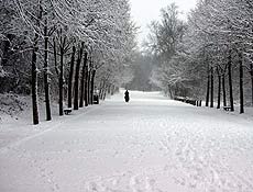 Mulher caminha em parque coberto de neve em Londres; aeroportos registraram atrasos