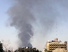Coluna de fumaa sai de mercado atingido por exploses de carros-bomba em Bagd 