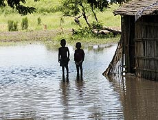 Crianas moambicanas em frente  casa inundada em Caia, na Provncia de Sofala