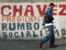 Homem passa por muro com os dizeres "Chvez, presidente, rumo ao socialismo"
