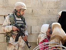 Soldado iraquiano vigia mulher e crianas que buscam assistncia mdica em Qargouli