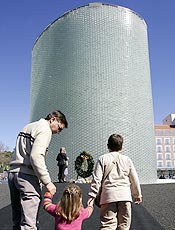 Famlia caminha em frente a monumento inaugurado em  Madri  