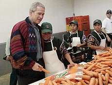 George W. Bush segura cenoura durante visita a lavradores maias na Guatemala