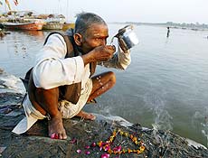 Hindu bebe gua poluda do rio Ganges em Allahabad, ndia; IPCC aponta risco de seca