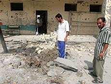 Iraquianos observam quadra destruda em escola ao leste de Bagd; um garoto morreu