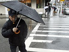 Pedestres enfrentam chuva em ruas de Nova York; tempestade mata 5 e prejudica vos