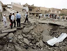 Iraquianos observam destruio causada por carros-bomba em estao de polcia de Bagd