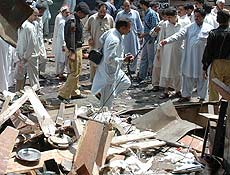 Paquistaneses observam local de exploso onde 25 pessoas morreram hoje em Peshawar