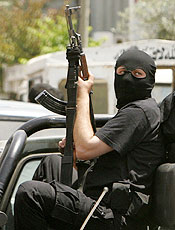 Membro armado do Hamas vigia funeral de integrante do grupo 