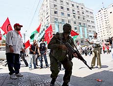 Membro armado do movimento Fatah exibe arma no centro da Cidade de Gaza