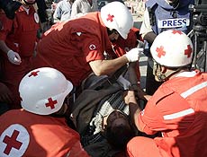 Membros da Cruz Vermelha atendem ferido após ataque contra campo de refugiados