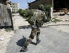 Soldado libans atravessa rua perto da entrada principal de campo de refugiados palestinos