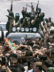 Membros armados do grupo radical Hamas passam por ruas Gaza