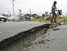 Ciclista leva bicleta por cratera aberta em rodovia no Japão após terremoto