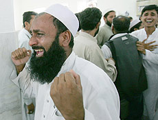 Muulmanos choram ao entrar na Mesquita Vermelha, em Islamabad (Paquisto)