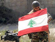 Soldado libans fixa a bandeira libanesa em blindado nas proximidades de Nahr al Bared