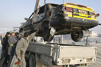 Policiais afegãos retiram táxi atingido por explosão ocorrida em Cabul