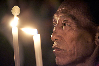 Texto: A Tibetan exile prays as he participates in a candlelit vigil in Dharamsala, India, Thursday, March 20, 2008. Tibetan spiritual leader the Dalai Lama said Thursday he was willing to meet Chinese leaders, including President Hu Jintao, as Chinese authorities acknowledged that anti-government riots in Tibet had spread to other provinces. (AP Photo/Gurinder Osan)