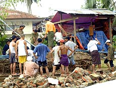 Mianmarenses se aglomeram em frente a resturante destruído pela passagem do ciclone