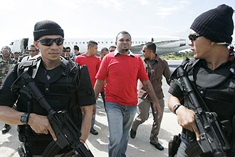 Policiais escoltam soldados rebeldes na chegada ao aeroporto de Díli; Indonésia extradita suspeitos de ataques a líderes timorenses