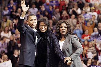 Texto: Democratic presidential candidate U.S. Senator Barack Obama (D-IL) (L), his wife Michelle (C) and talk show host Oprah Winfrey wave to the crowd at a campaign rally in Manchester, New Hampshire December 9, 2007. REUTERS/Brian Snyder (UNITED STATES)