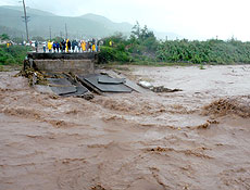 Jamaicanos observam ponte destruda pelas chuvas causadas por Gustav em Kingston