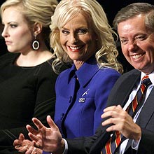Cindy McCain, wife of Republican presidential candidate, Sen. John McCain, R-Ariz., flanked by her daughter Meghan and Sen. Lindsey Graham, R-S.C., gestures prior to a town hall-style presidential debate between nominees, Republican John McCain and Democrat Barack Obama, and at Belmont University in Nashville, Tenn., Tuesday, Oct. 7, 2008. (AP Photo/Pool, Charles Dharapak)