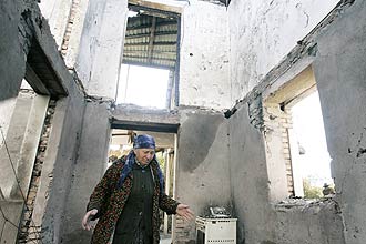 Georgiana em meio aos escombros de sua casa; presidente<br> da Geórgia afirma ter recebido apoio de Barack Obama