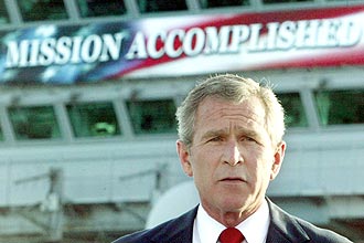 Bush discursa sobre Guerra do Iraque a frente de faixa com frase "Misso Cumprida"; um dos erros admitidos pelo presidente