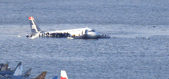 Passageiros deixam avião que pousou sobre o rio Hudson, em Nova York, e aguardam socorro sobre as asas