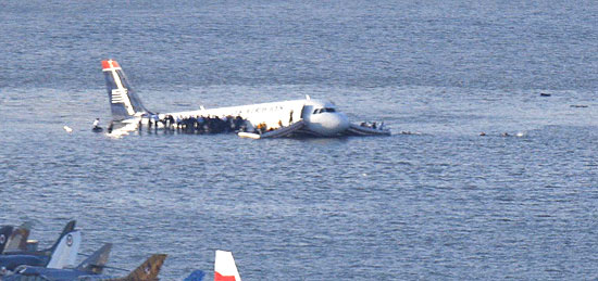 Passageiros deixam avio que pousou sobre o rio Hudson, em Nova York, e aguardam socorro sobre as asas