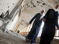 Palestinas caminham em corredor de escola destruída durante ofensiva na faixa de Gaza