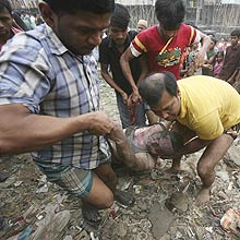 Populao carrega corpo de membro da Bangladesh Rifles morto no conflito