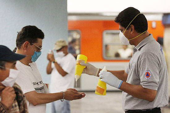 Funcionários do metrô de Cidade do México distribuem gel para que mexicanos mantenham as suas mãos limpas