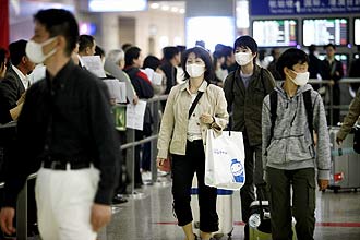 Turistas usam mscaras de proteo ao chegar ao Aeroporto Internacional Shanghai Pudong, na China, para evitar contaminao por gripe