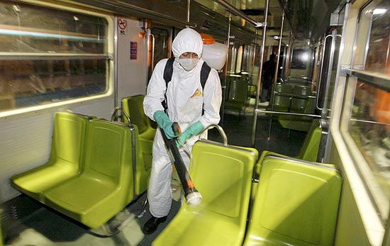 Funcionrio veste roupa de proteo para desinfectar o interior de um vago de trem e evitar contgio do vrus