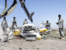 Policiais afegos observam veculo destrudo por bomba de controle remoto em Nangarhar 